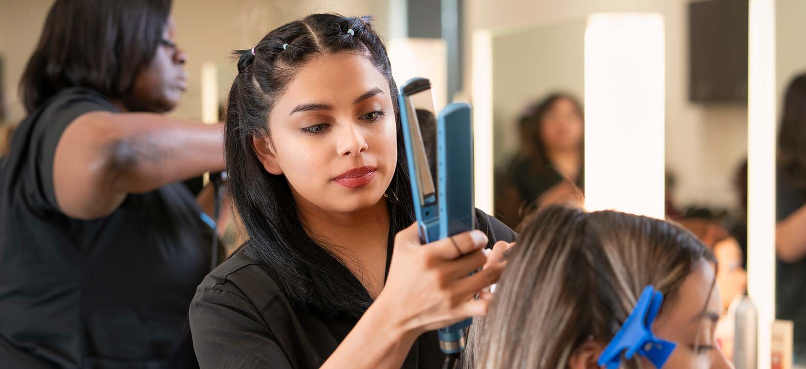 cosmetology student straightening hair on client