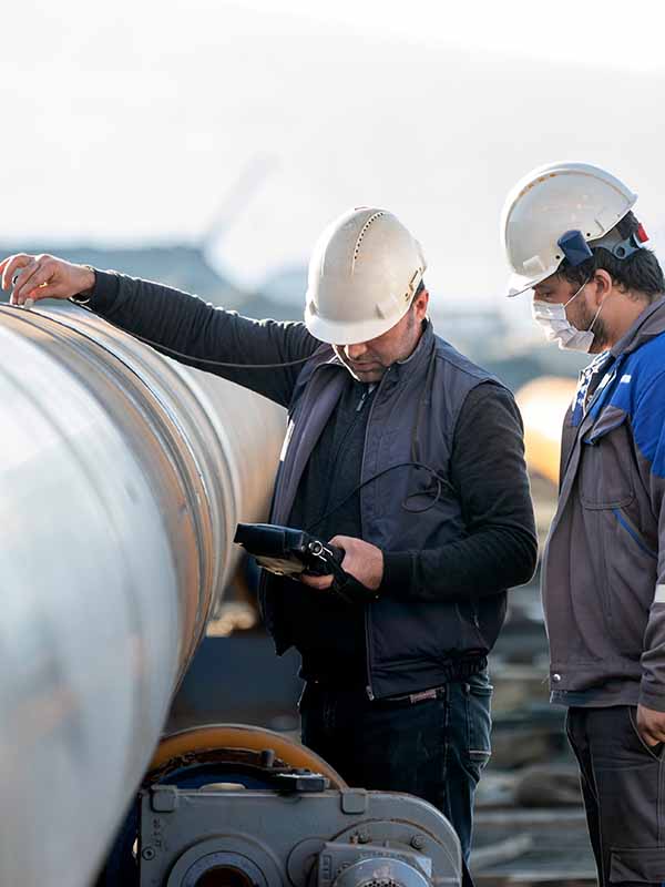 Man in hard hat in front of industrial site